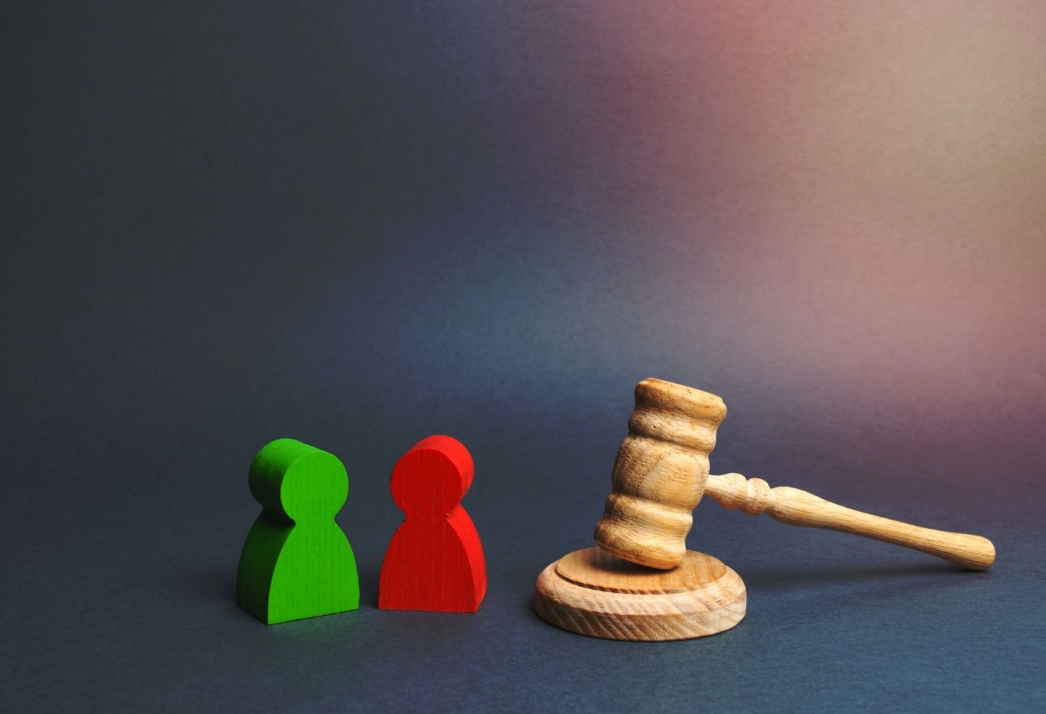 A gavel and a red and green human icon figure side by side. A representation of Legal Disputes in Crossborder Trade.